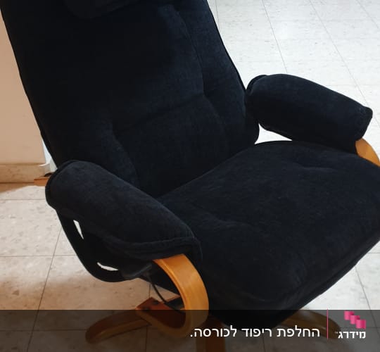 כורסה מרופדת בצבע שחור עם רגלי עץ